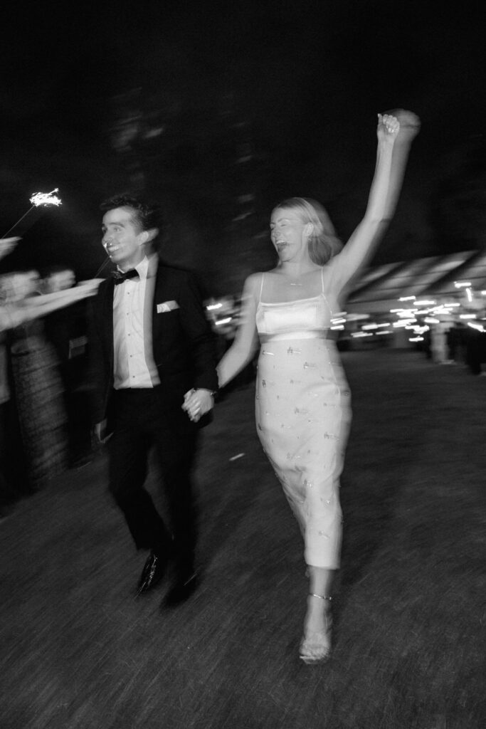 black and white of bride and groom exiting wedding reception